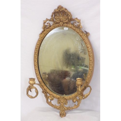 223 - Victorian gilt framed oval wall mirror with foliate decoration and sconces