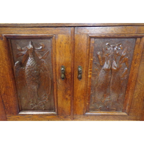 30 - Victorian oak cabinet with ornate bird decorated carved doors, frieze drawer, on carved legs