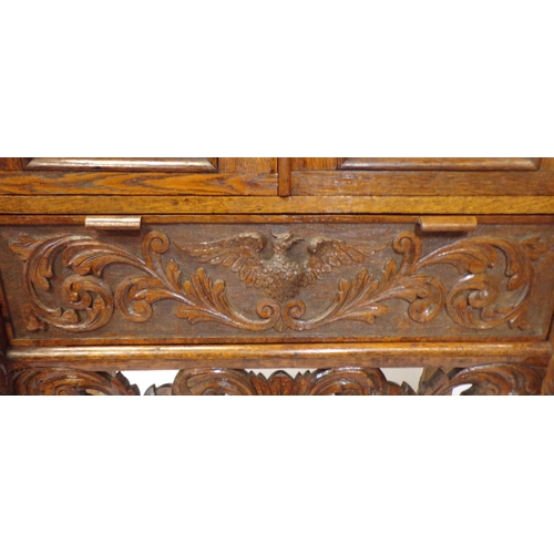 30 - Victorian oak cabinet with ornate bird decorated carved doors, frieze drawer, on carved legs