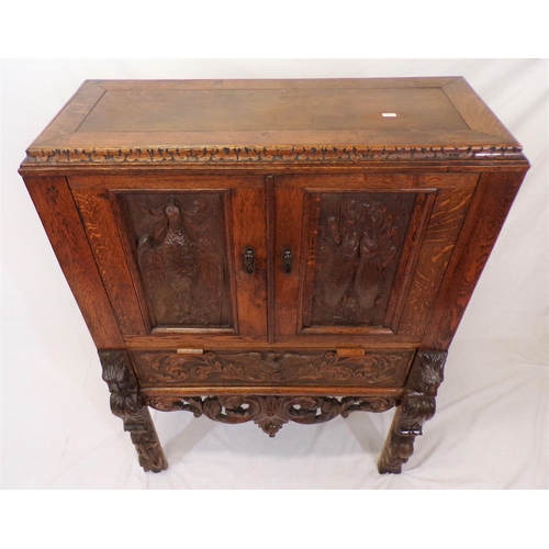 30 - Victorian oak cabinet with ornate bird decorated carved doors, frieze drawer, on carved legs