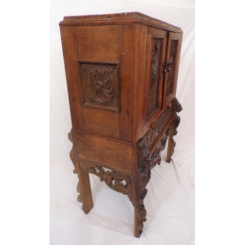 30 - Victorian oak cabinet with ornate bird decorated carved doors, frieze drawer, on carved legs