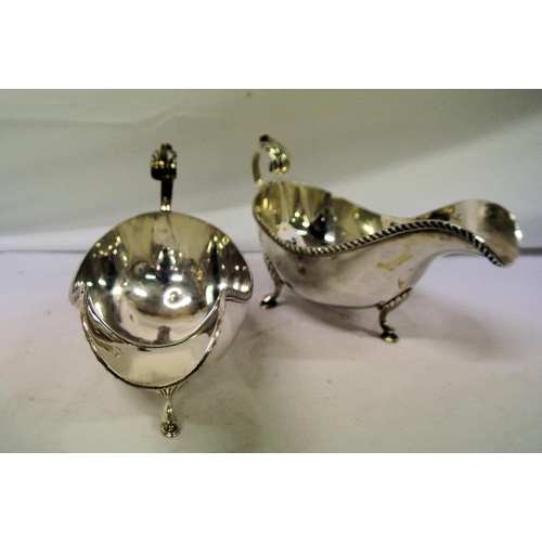 6 - Pair of heavy silver plated sauceboats with gadroon rims and leaf capped scroll handles, each on thr... 