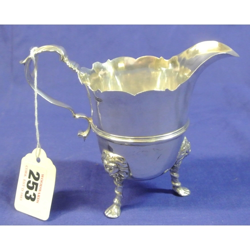 253 - Irish silver cream jug with wavy rim, shaped handle. 3 cast feet with figured knuckles, by Croker Ba... 