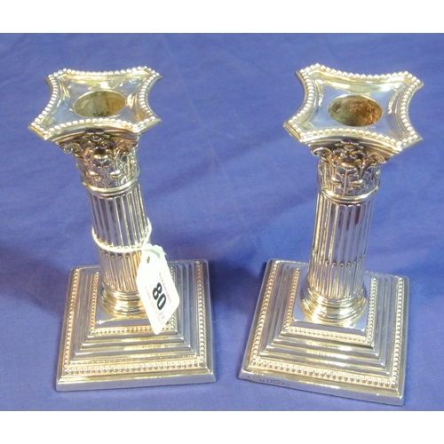 80 - Pair of Sheffield silver dwarf candlesticks with reeded columns, shaped sconces, on stepped bases. 1... 