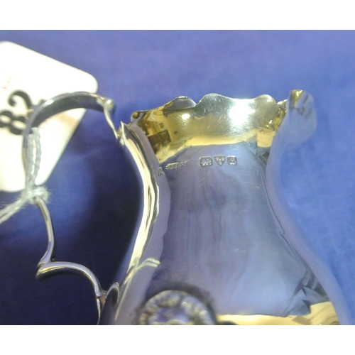 82 - Chester silver baluster shaped creamewer with wavy rim and handle, on shaped feet.