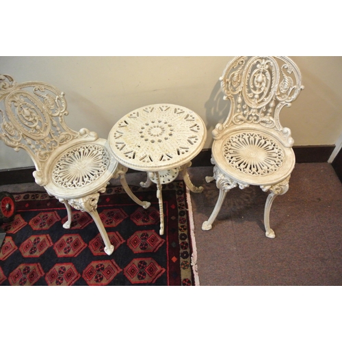 157 - Three piece cast iron garden or patio set, round table and pair of chairs with ornate scroll decorat... 