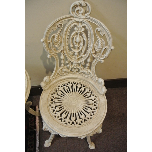 157 - Three piece cast iron garden or patio set, round table and pair of chairs with ornate scroll decorat... 