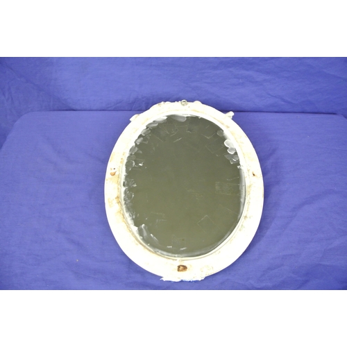 167 - Oval Dresden style porcelain framed mirror with ornate cherub and foliate encrustation
