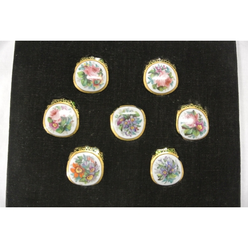 168 - Set of seven foliate decorated enamel and green glass jar tops in presentation case