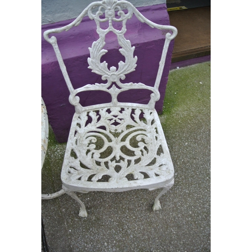 183 - Three piece wrought iron garden or patio suite with foliate decoration, table and two  shaped backed... 