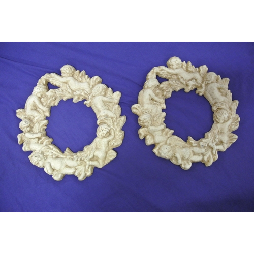 187 - Pair of cast iron round frames with foliate and cherub decoration