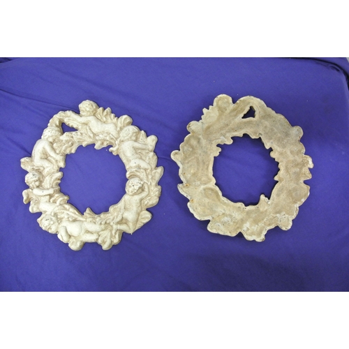 187 - Pair of cast iron round frames with foliate and cherub decoration