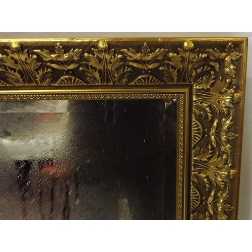 64 - Edwardian design gilt framed bevelled glass wall mirror with ornate foliate decorated frame