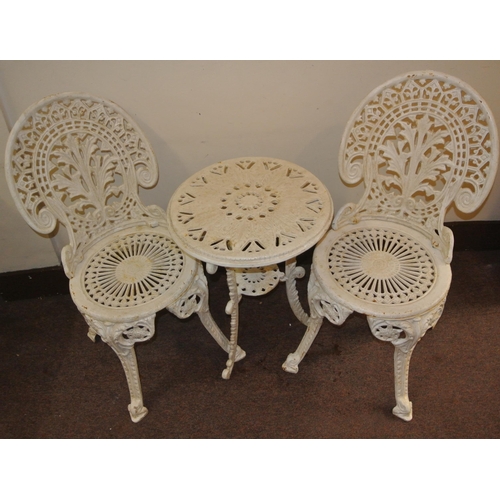 119 - Ornate cast iron three piece garden or patio suite - two domed chairs and round table with foliate d... 