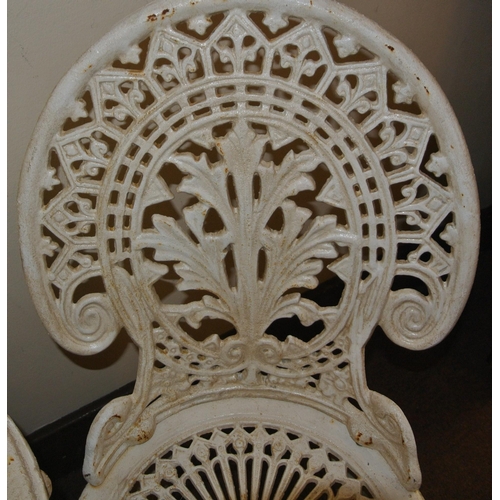 119 - Ornate cast iron three piece garden or patio suite - two domed chairs and round table with foliate d... 