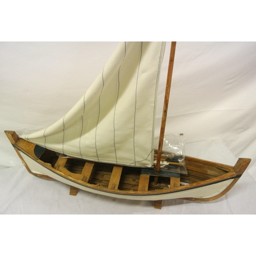 157 - Handmade timber model of a sailing skiff on stand Length 62cm by 17cm mast 57cm