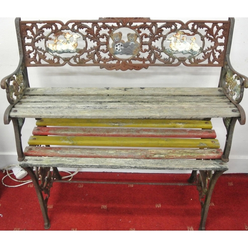 181 - Child's cast iron garden bench and lacquered table with ornate and teddy bear decoration