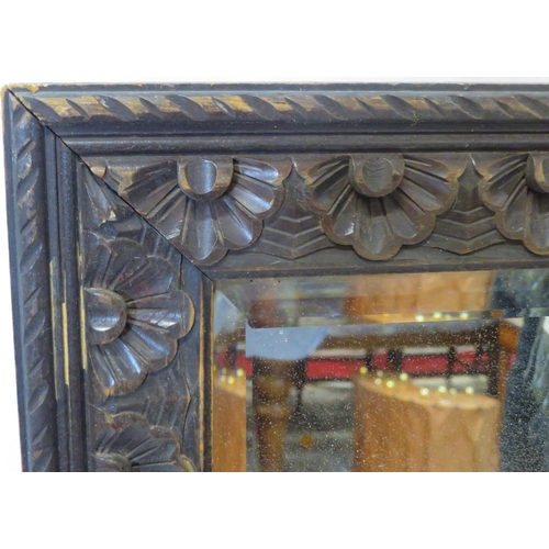 27 - Edwardian carved oak bevelled glass wall mirror with foliate decoration