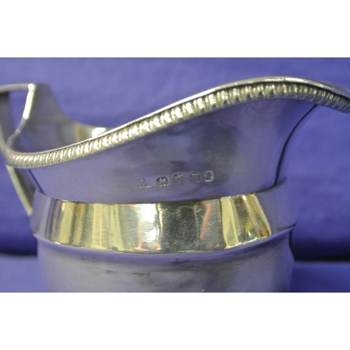 176 - Georgian London silver cream jug of oval bulbous form with gadroon rim, shaped handle, on stepped ba... 