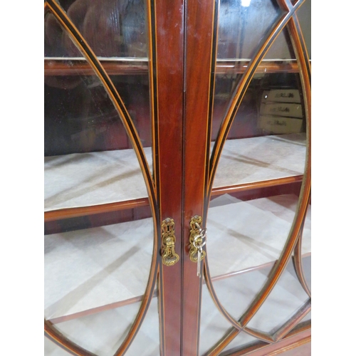 150 - Edwardian inlaid mahogany bookcase or cabinet with glazed doors, ornate fretwork, shelved interior, ... 