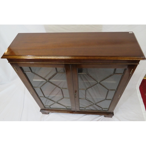 20 - Edwardian mahogany bookcase with glazed doors, reeded shelving, on bracket feet