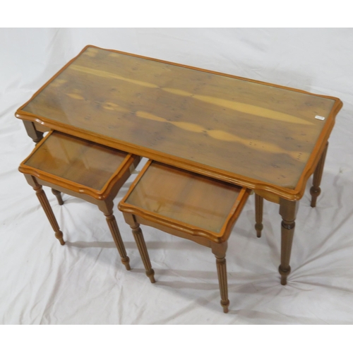 24 - Nest of 3 yew coffee tables with glass inset, on reeded tapering legs