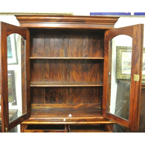 25 - Victorian style bookcase with shaped leaves, glazed doors with shelved interior, shelved press under... 