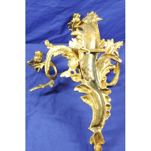 63 - Ornate brass wall bracket with shaped sconces, and foliate decoration