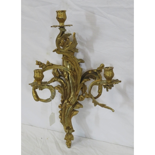 63 - Ornate brass wall bracket with shaped sconces, and foliate decoration