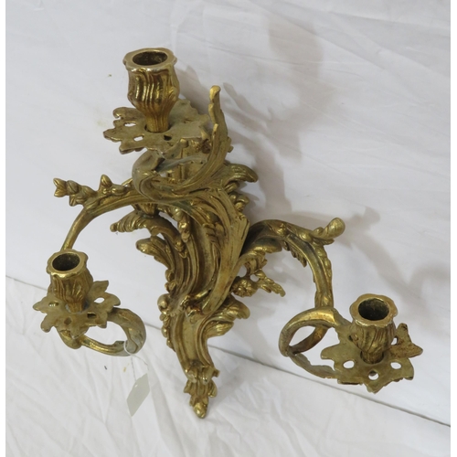 63 - Ornate brass wall bracket with shaped sconces, and foliate decoration