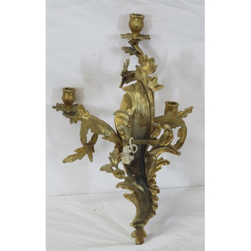 63 - Ornate brass wall bracket with shaped sconces, and foliate decoration