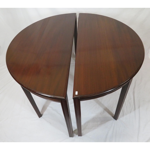 75 - Pair of Edwardian mahogany demi-lune side or alcove tables with rounded borders, raised on reeded ta... 