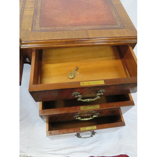 100 - Edwardian mahogany pedestal desk with seven drawers, leatherette inset, brass drop handles, on cabri... 