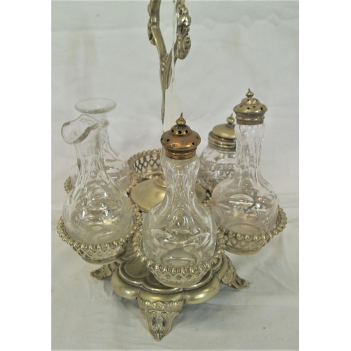 25 - Victorian style silver plated cruet set with bottles, round holders, shaped handle and cast feet