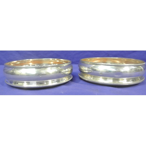 101 - Pair of London silver round wine coasters with beaded rims and bulbous bodies, timber bases, 13cm di... 