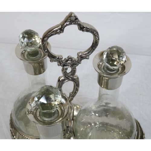 34 - Victorian silverplated tantalus with 3 glass bottles inset, on shaped base