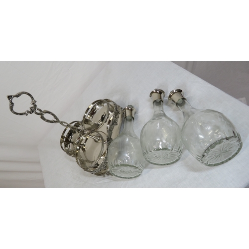 34 - Victorian silverplated tantalus with 3 glass bottles inset, on shaped base