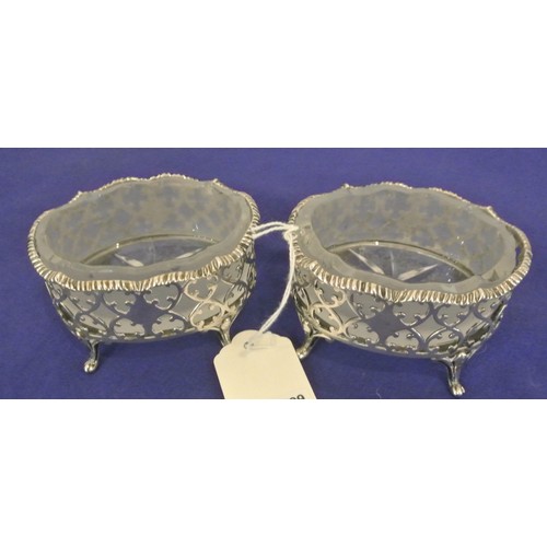 113 - Pair of Victorian London silver oval salts with ornate piercing shaped rims, hand cut glass liners, ... 