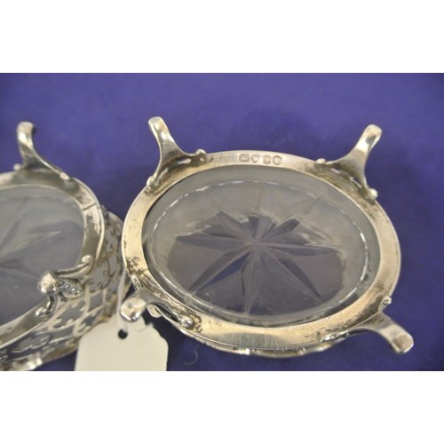 113 - Pair of Victorian London silver oval salts with ornate piercing shaped rims, hand cut glass liners, ... 