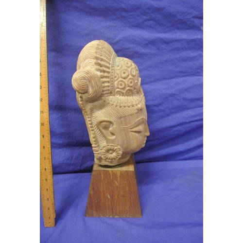 58 - Oriental carved sandstone bust on tapering timber base