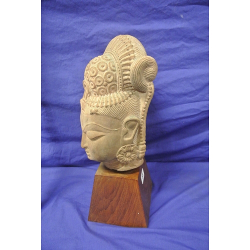 58 - Oriental carved sandstone bust on tapering timber base