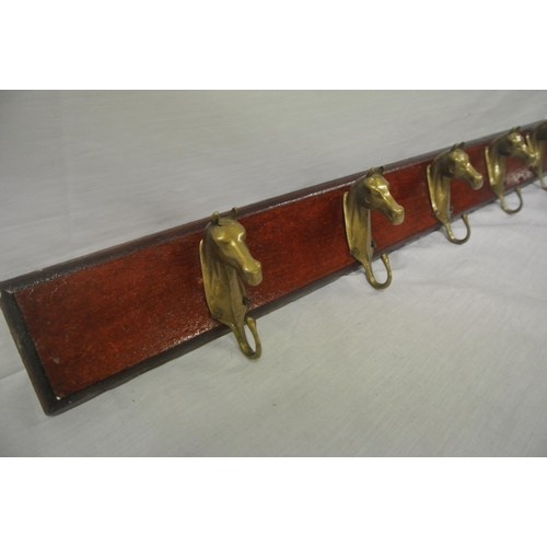 63 - Brass horse shaped coat hangers with timber back plate