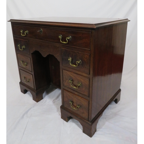 65 - Edwardian mahogany kneehole desk with seven drawers, shaped brass drop handles, on bracket feet