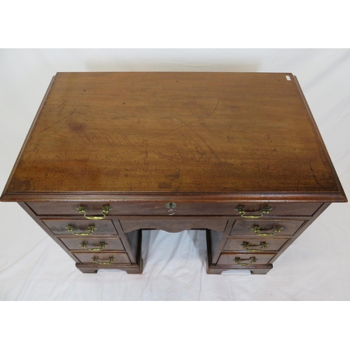 65 - Edwardian mahogany kneehole desk with seven drawers, shaped brass drop handles, on bracket feet