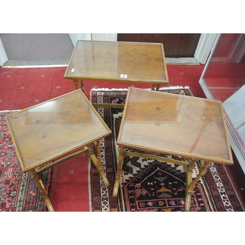 86 - Victorian nest of three yew tables with glass tops, raised borders, turned columns & stretchers, wit... 