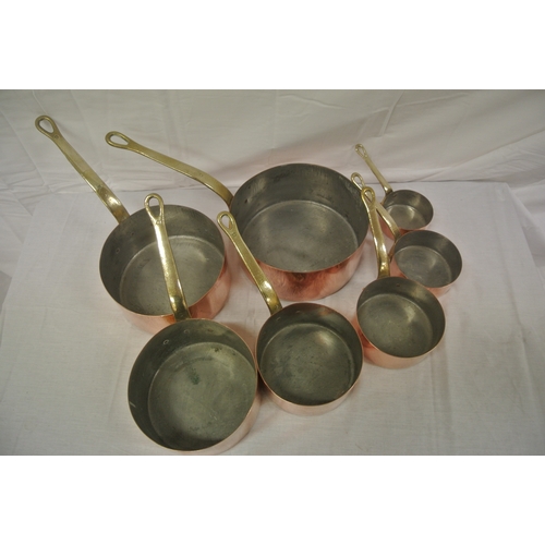 198 - Set of six copper pans with shaped brass handles