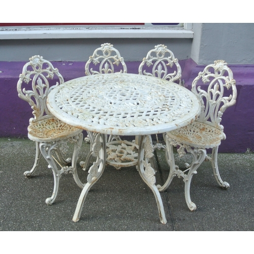 275 - Seven piece cast iron garden or patio suite - round table & six chairs with ornate foliate decoratio... 