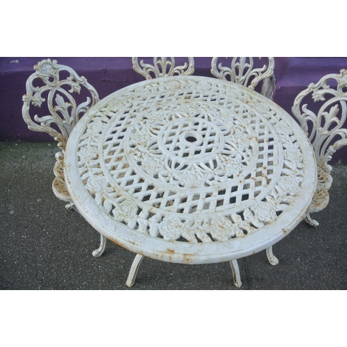 275 - Seven piece cast iron garden or patio suite - round table & six chairs with ornate foliate decoratio... 