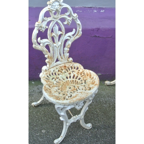 275 - Seven piece cast iron garden or patio suite - round table & six chairs with ornate foliate decoratio... 