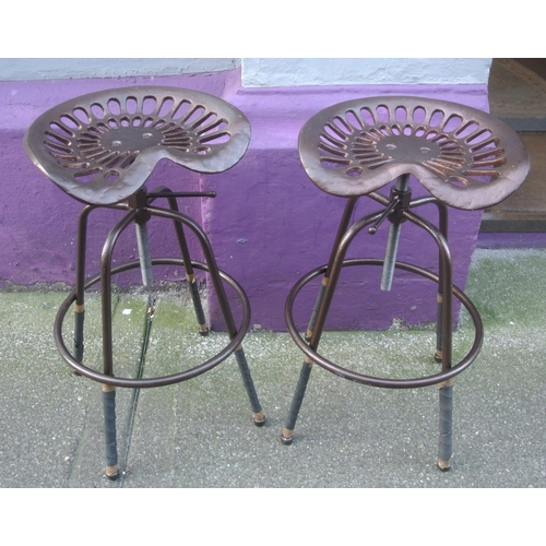 296 - Pair of cast iron tractor seats mounted as stools with swivel tops